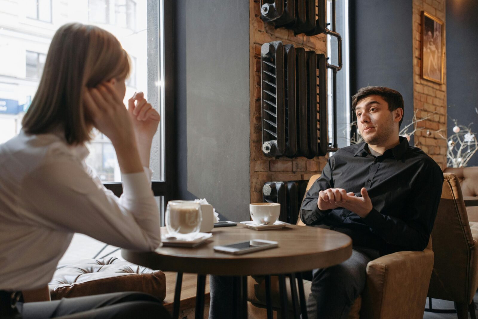 Relaxed meeting in a cozy café with two people discussing over coffee.